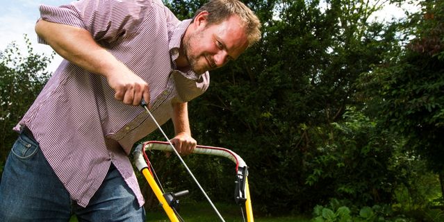 man trying to start a lawnmower